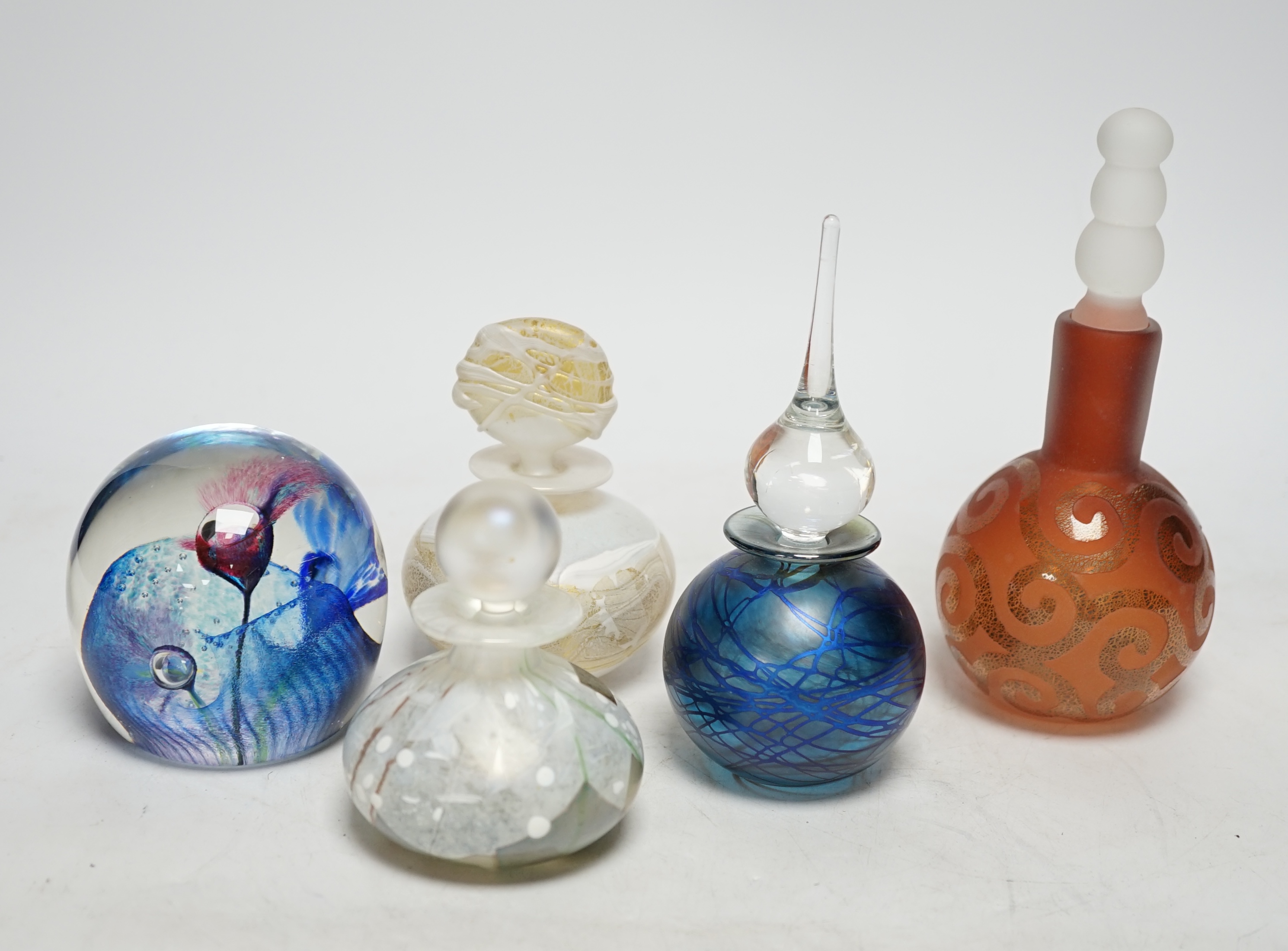 Four perfume bottles possibly by Blow Zone and paperweight by Helen Millard, tallest 17cm high